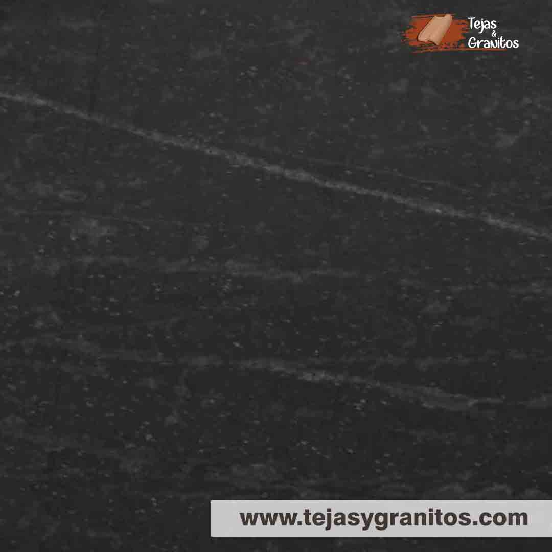 Granito Black Motion tiene fondo negro con vetas blancas y puntos rojizos.